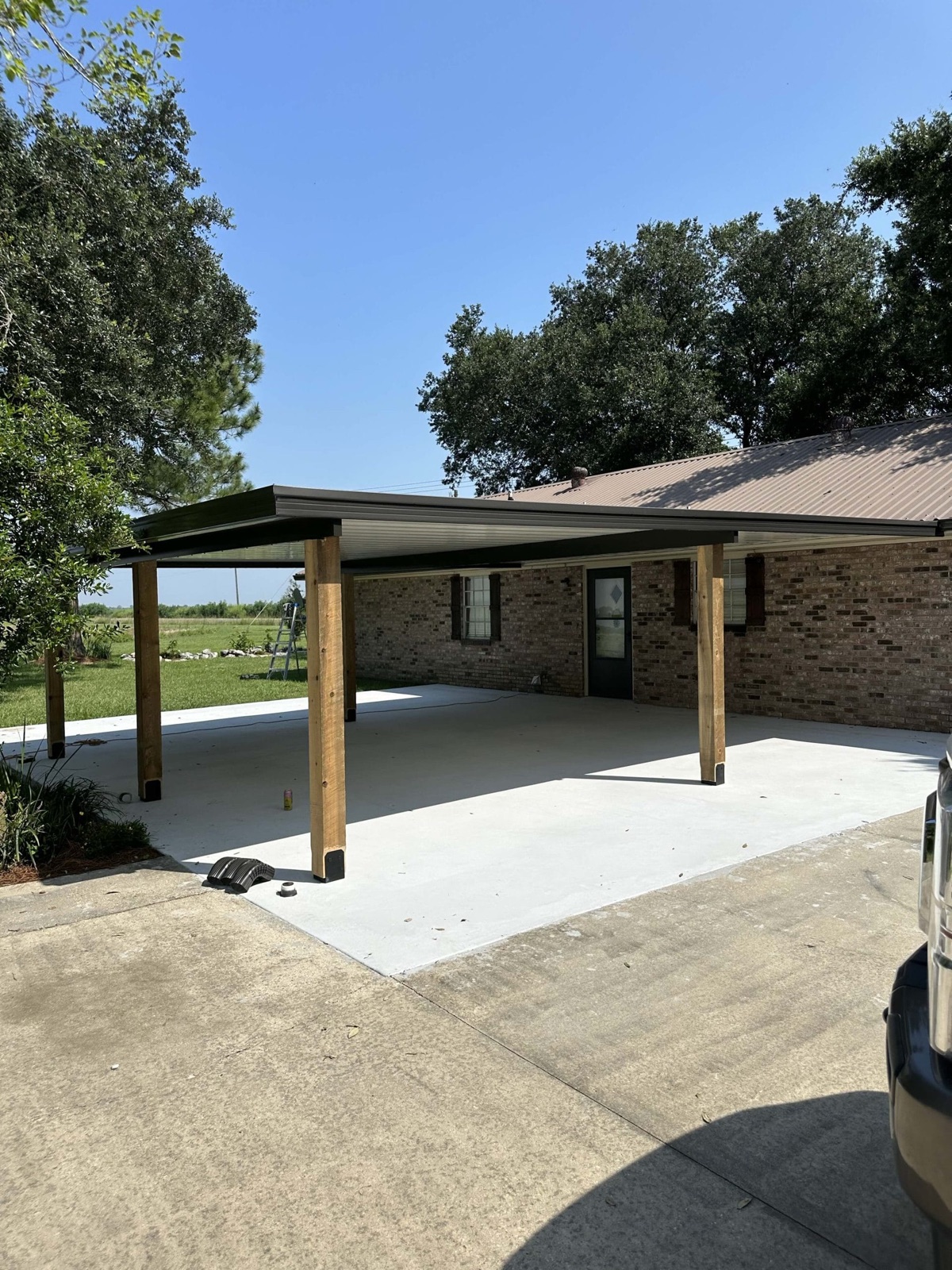 Aluminum patio cover and concrete slab completed on a brick home by A.L.I. Home Improvement